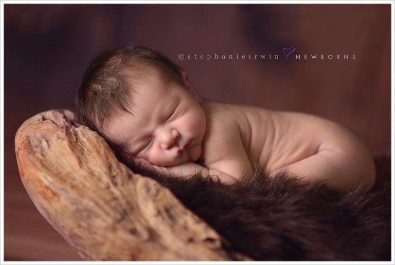 baby boy in wood piece by Markham baby photographer
