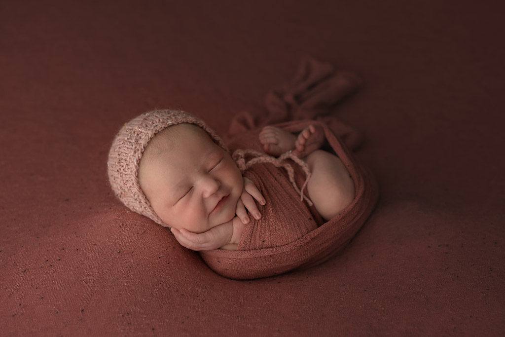 Toronto newborn photography of sleeping girl in coral setup and wrap